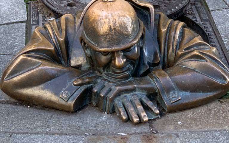 Bratislava Fussgaengerzone Mann im Gully